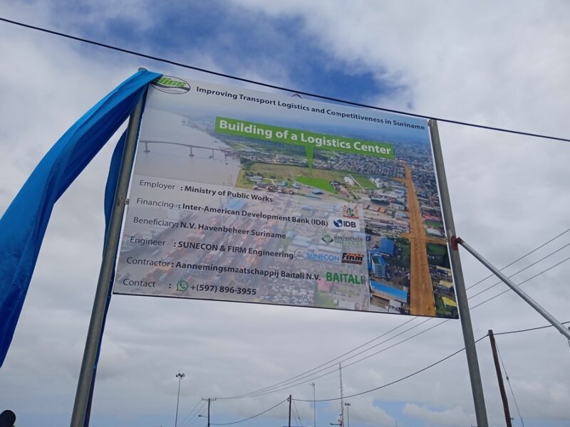 Op het bord staat informatie over de bouw van het logistiek centrum.