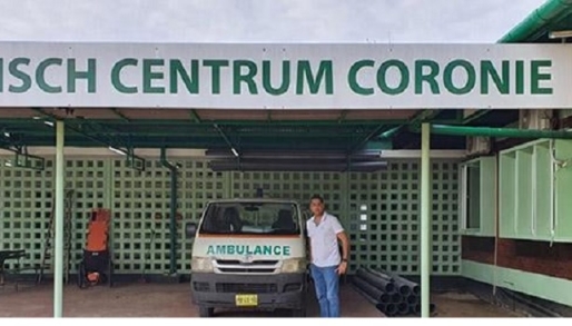 Minister Amar Ramadhin staat bij een ambulance bij de RGD-poli van Coronie