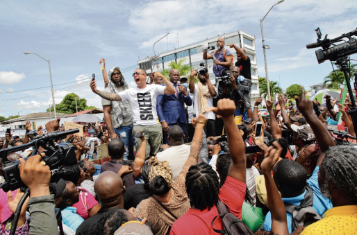 De Surinaamse vicepresident Ronnie Brunswijk (midden, in pak met stropdas) spreekt actievoerders toe tijdens een demonstratie in Parmaribo. Foto Ranu Abhelah/ANP 