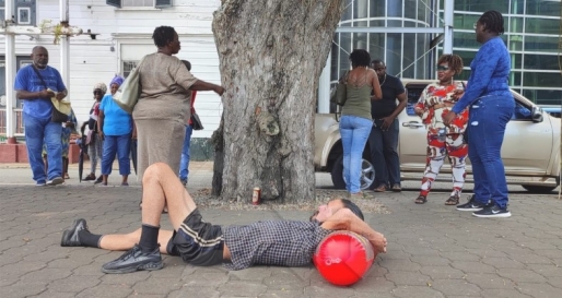 Ronald Fernandes, woordvoerder van de dak- en thuislozen, was er vandaag ook bij om de actie te ondersteunen. Hij lag op de grond als teken van protest. Foto: Suriname Herald